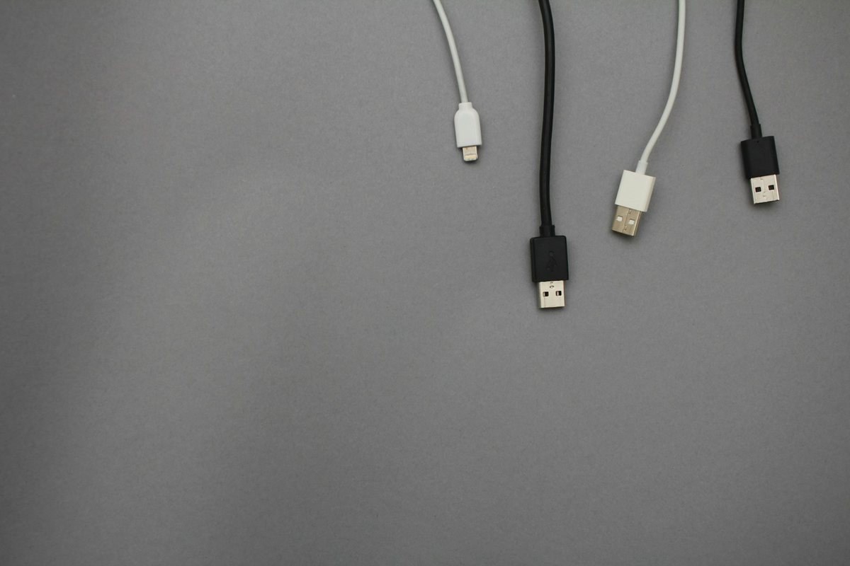 Black and white USB charging cables laid out on a gray surface