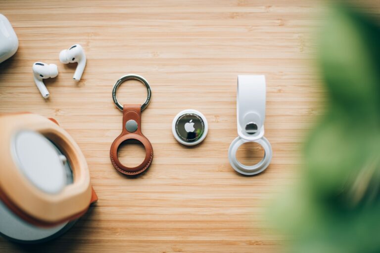 Bluetooth tracker tags and key rings laid out on a wooden table