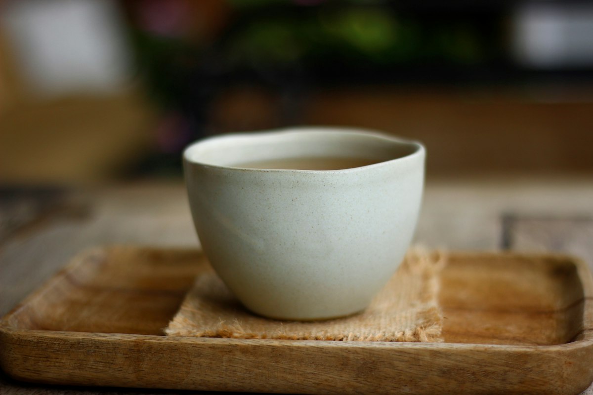 Handmade ceramic teacup on a wooden tray