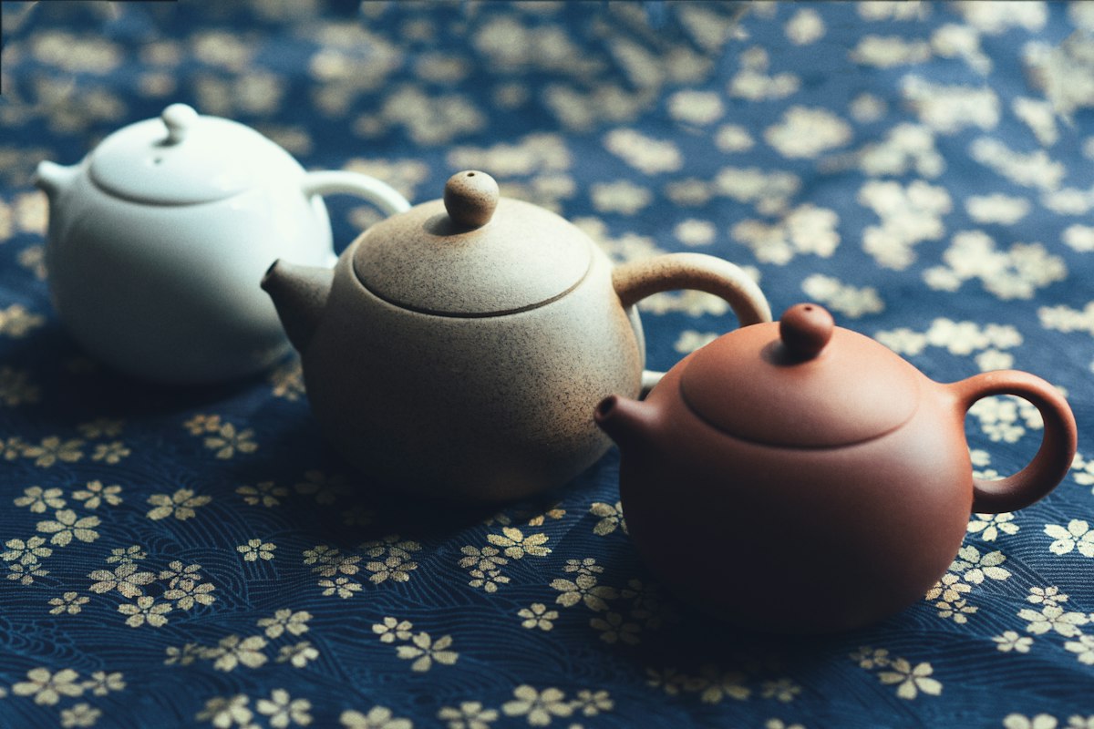 Ceramic teapots on a blue floral cloth