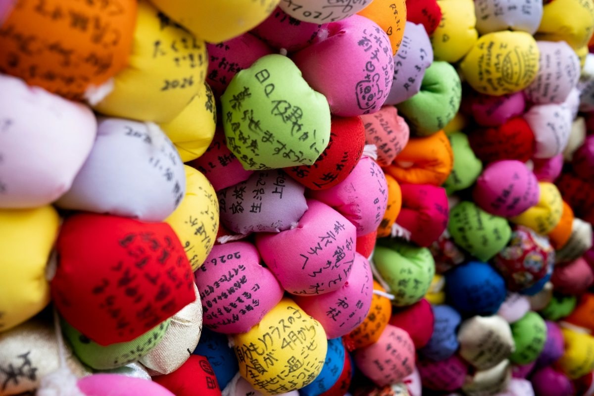 Colorful good-luck charms with handwritten Japanese messages at a Kyoto shrine