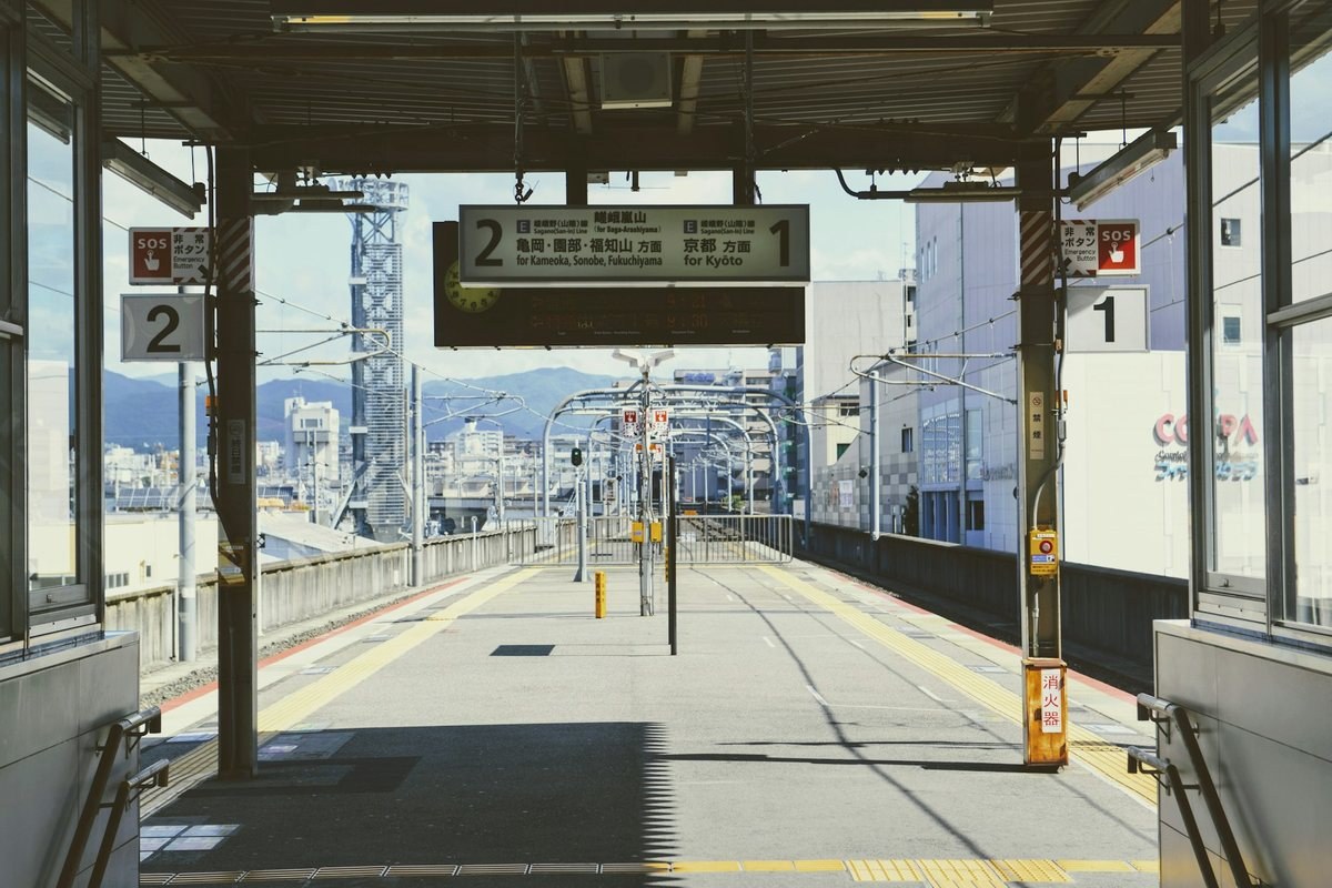 Empty train station platform in Kyoto, Japan with signs for Kyoto-bound trains