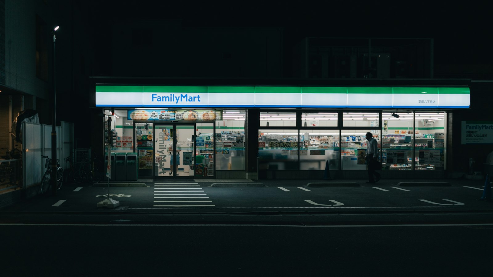 A FamilyMart lit up on a quiet street at night