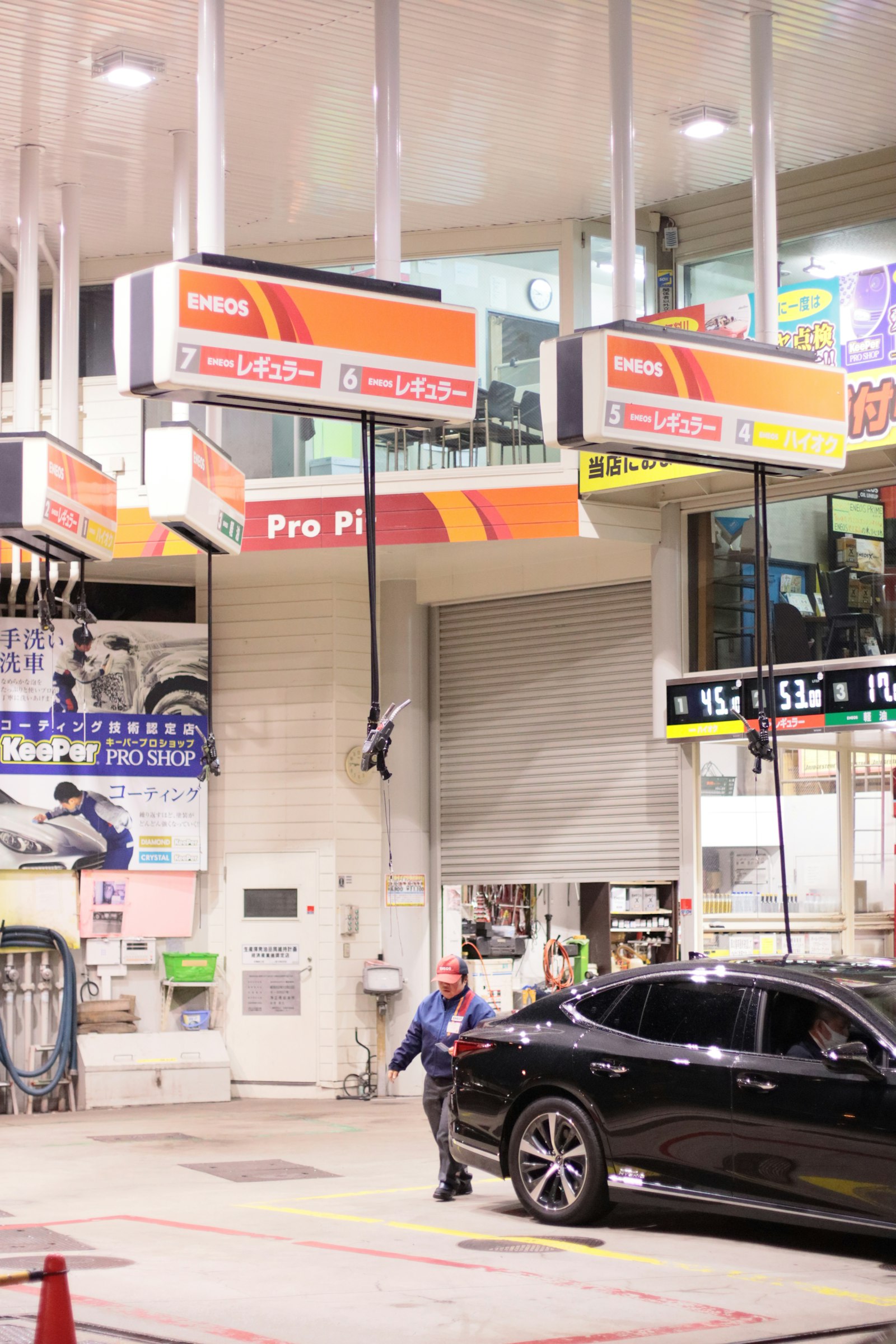 Staff guiding a car at a Japanese gas station