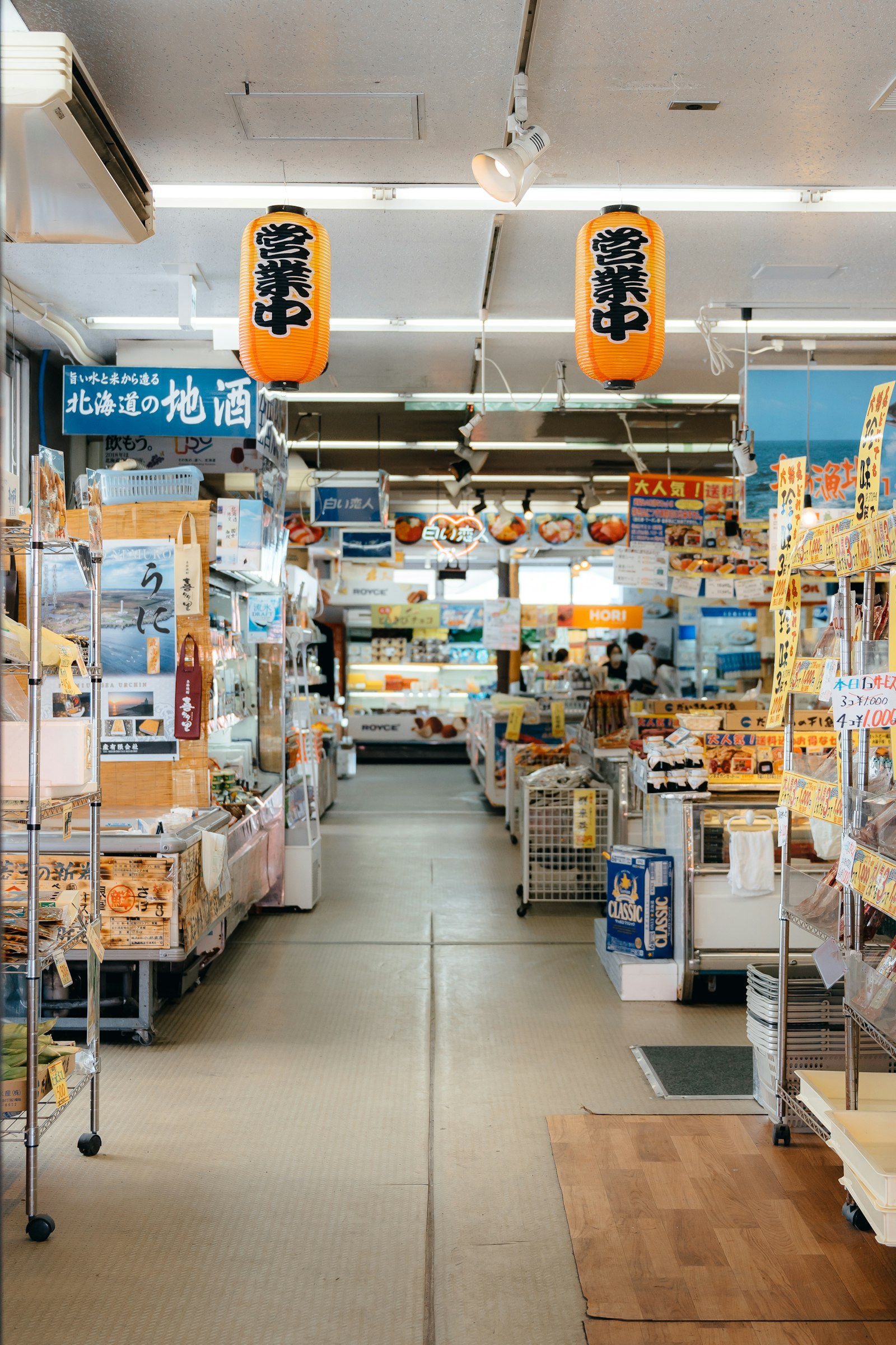 Aisles of a busy Japanese store stocked with food and daily goods