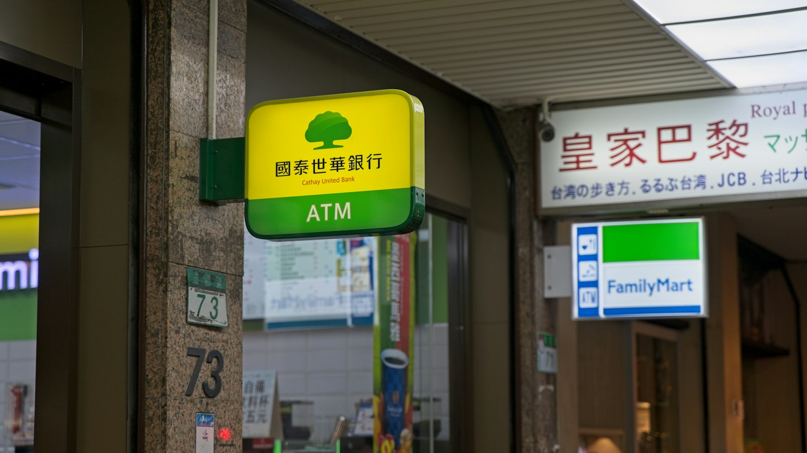 Japan Post Bank ATM sign next to a FamilyMart entrance
