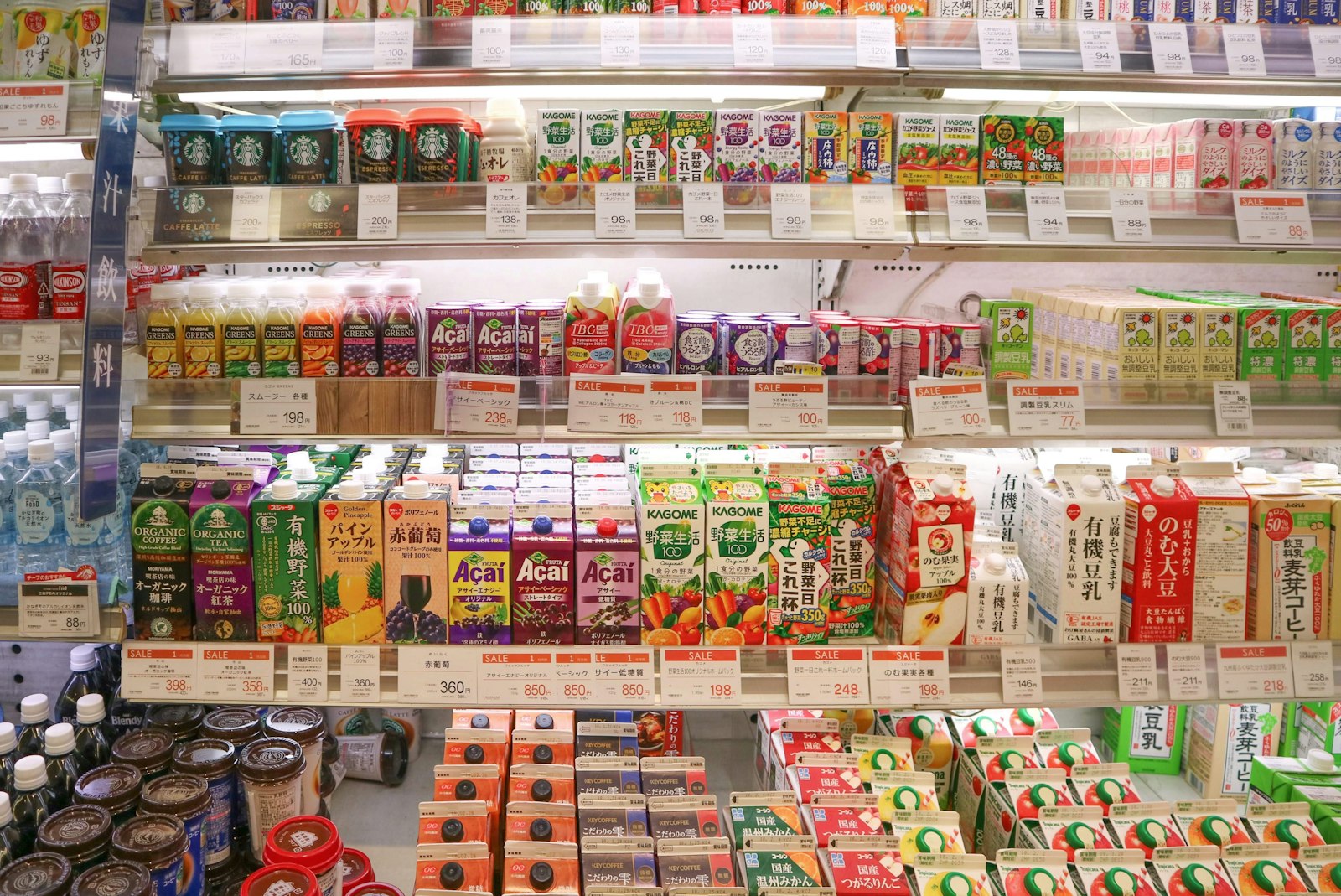 Brightly lit shelves of drinks and packaged snacks in a Japanese convenience store