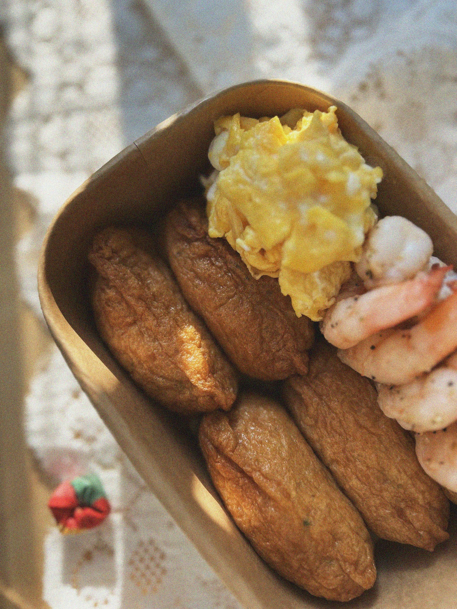 Takeaway box of inari sushi with egg and shrimp