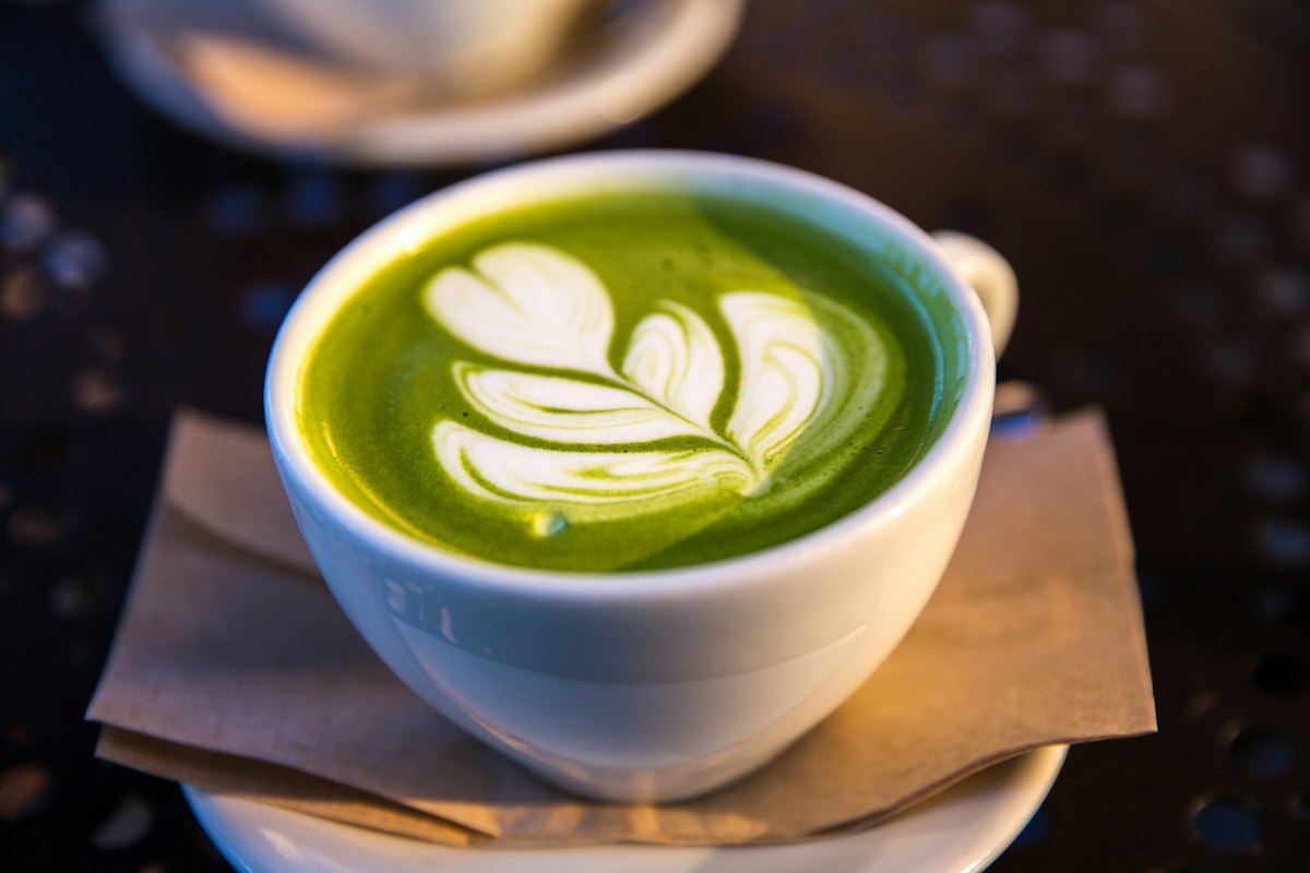 Matcha latte with latte art in a white cup