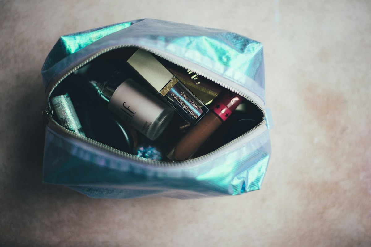 Open toiletry pouch filled with cosmetics and bottles