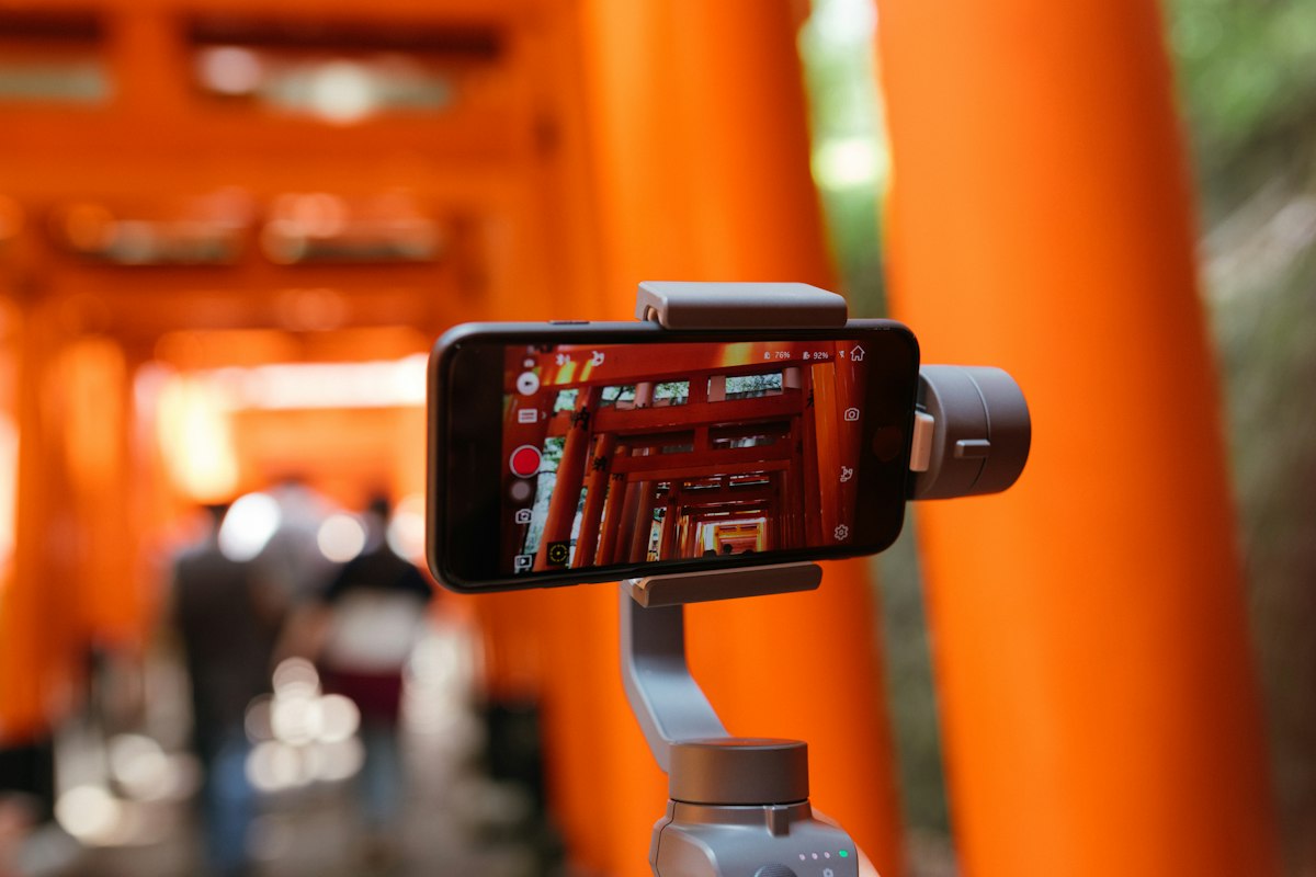 Smartphone on a gimbal filming red torii gates