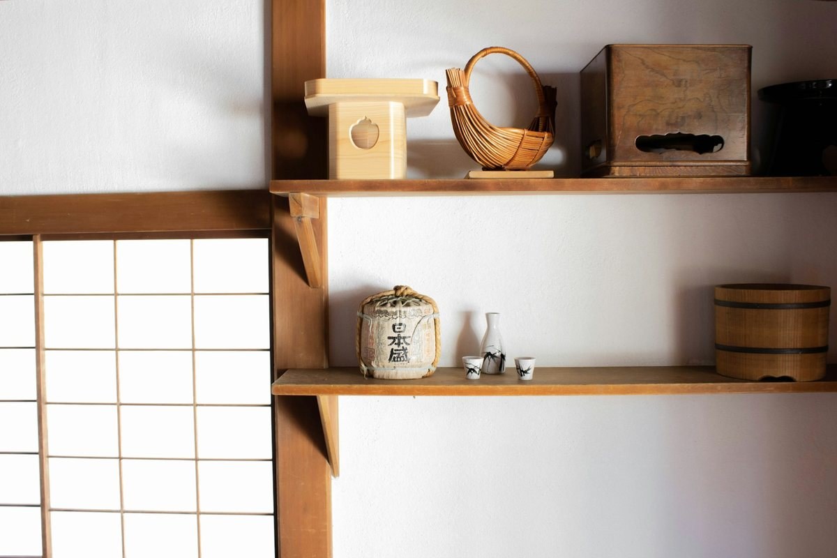 Simple wooden shelves in a Japanese-style room with baskets, boxes and sake cups