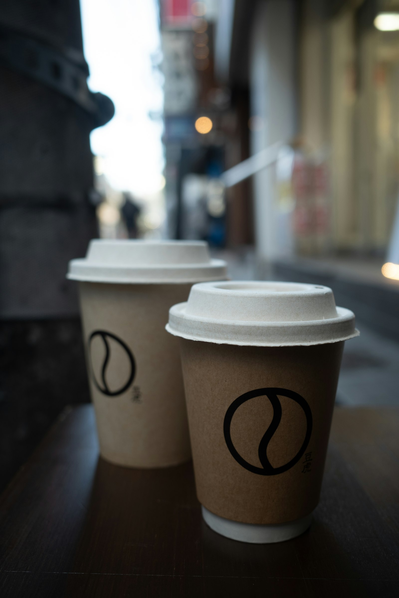 Two hot takeaway coffee cups with lids