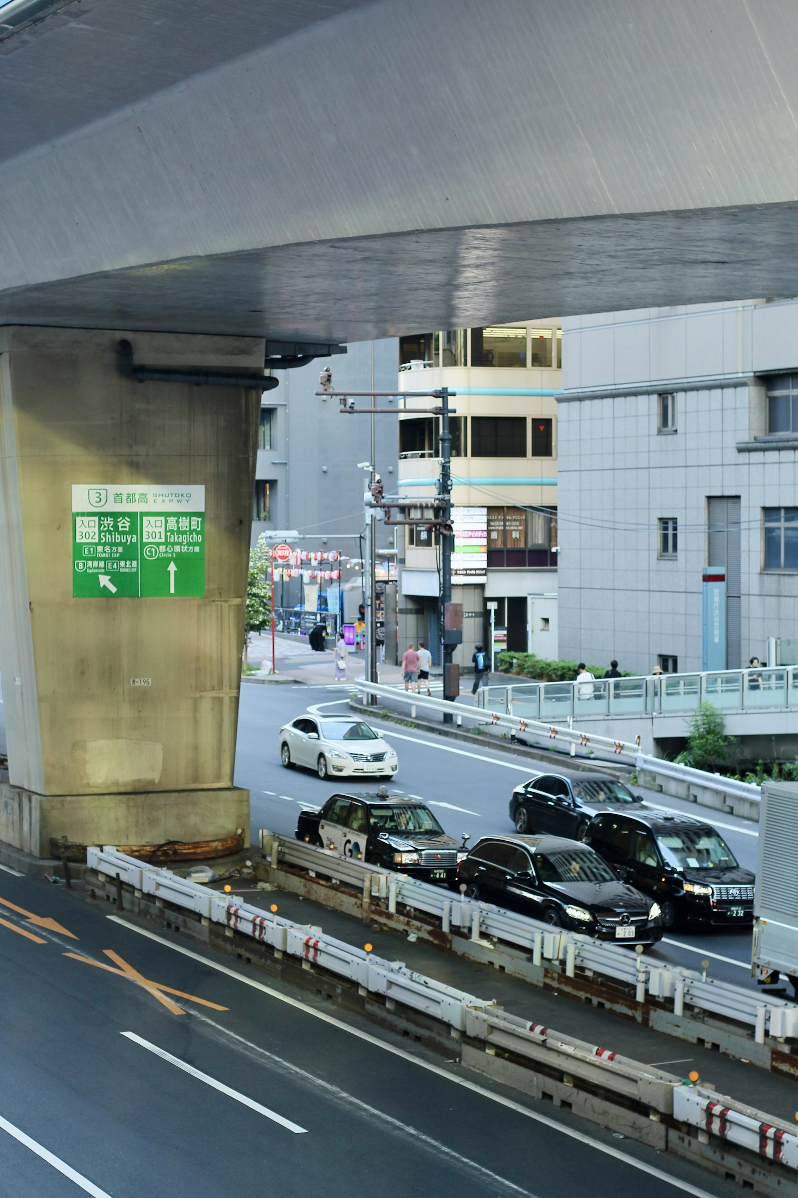 Cars and taxis under an elevated expressway in Tokyo
