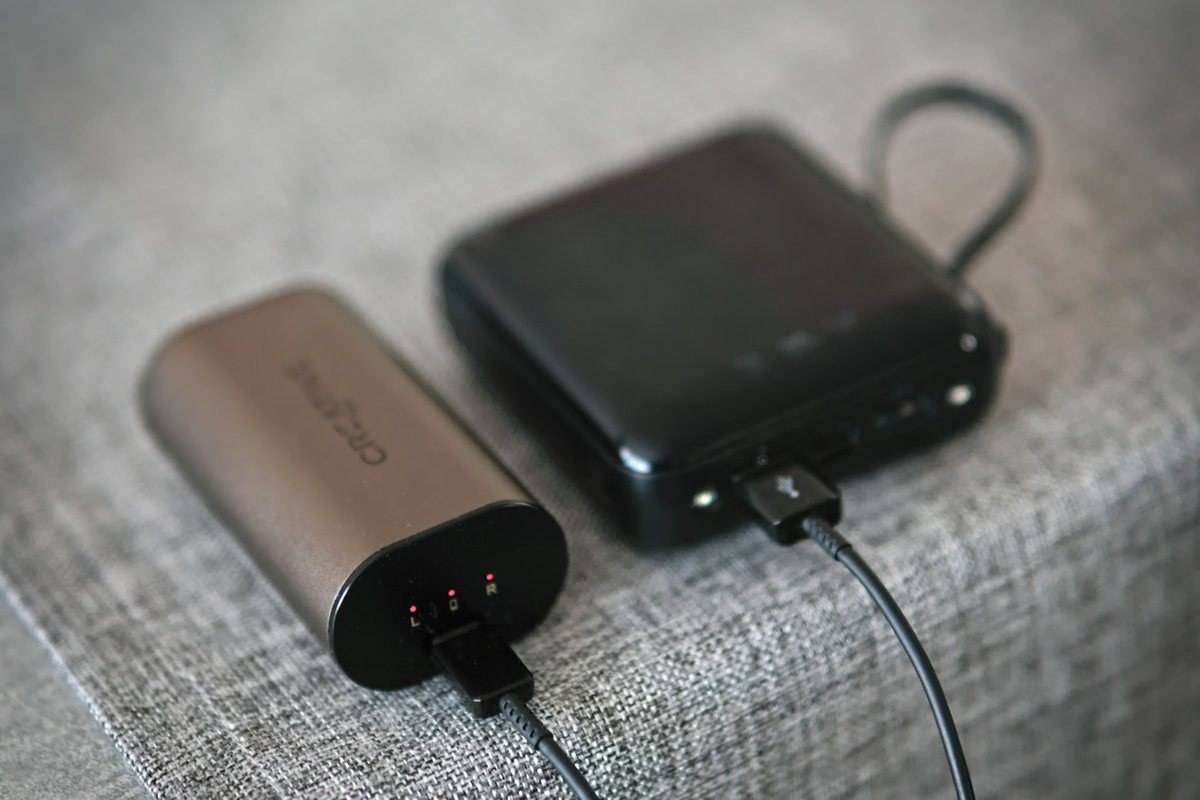 Two power banks charging on a fabric surface