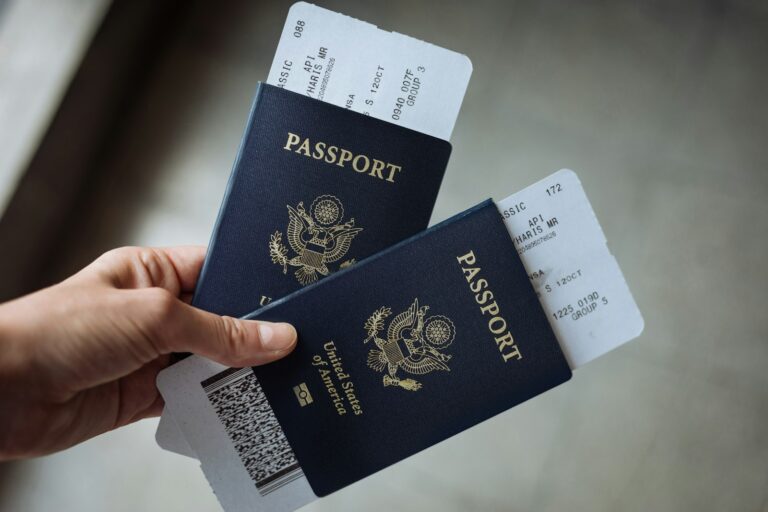 Two US passports with boarding passes held in a hand