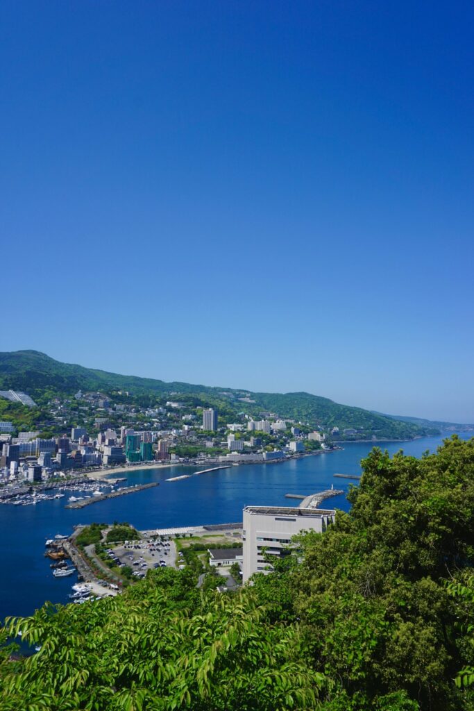 Atami hot spring town and harbor along the blue bay seen from the hillside