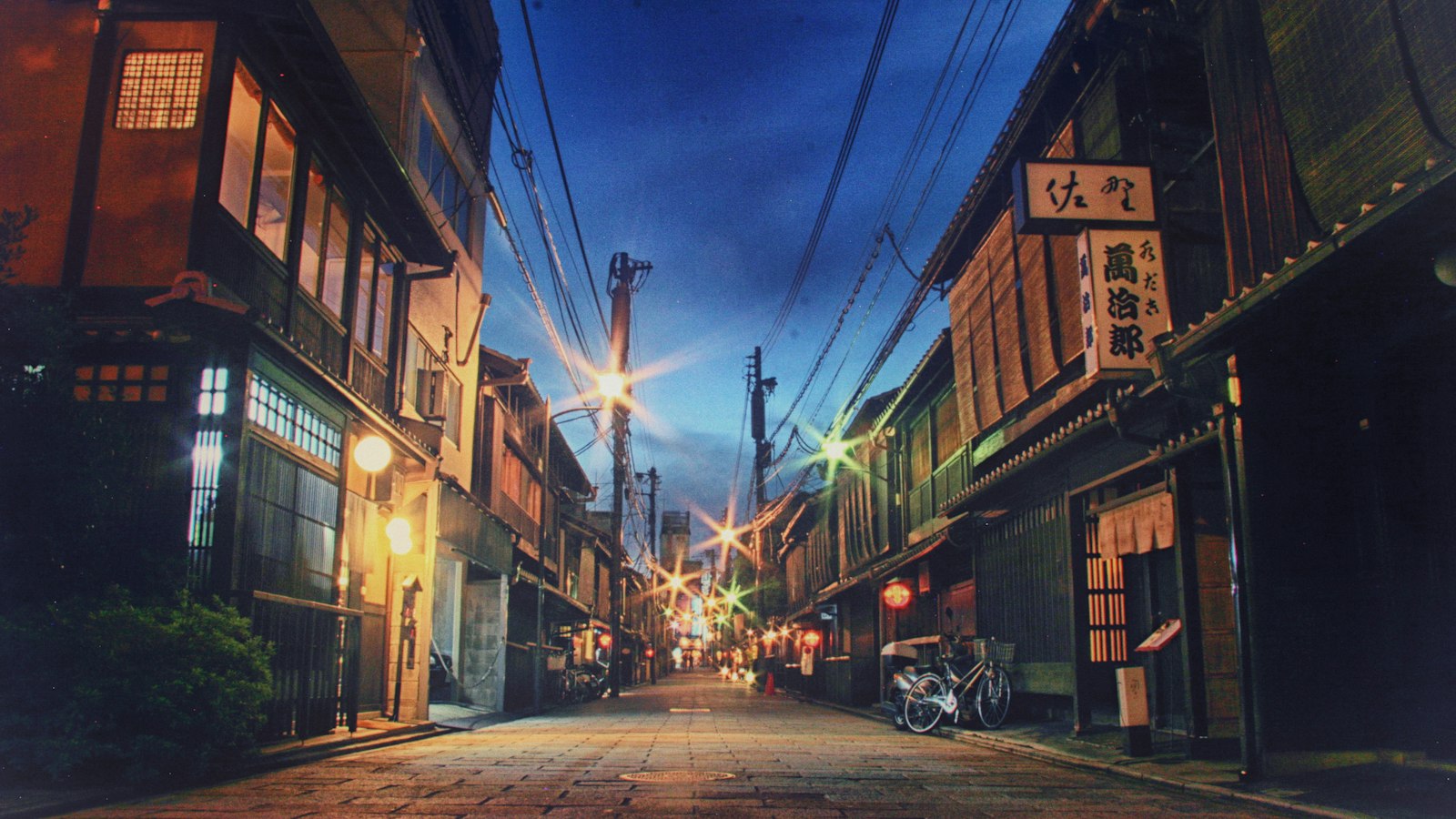 Wooden machiya townhouses along a Gion street at dusk in Kyoto