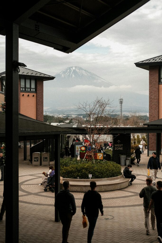 Shoppers in the open-air plaza of Gotemba Premium Outlets with Mount Fuji rising behind
