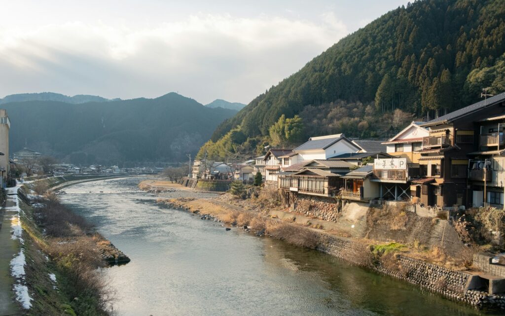 Traditional houses along the river in Gujo Hachiman, framed by mountains