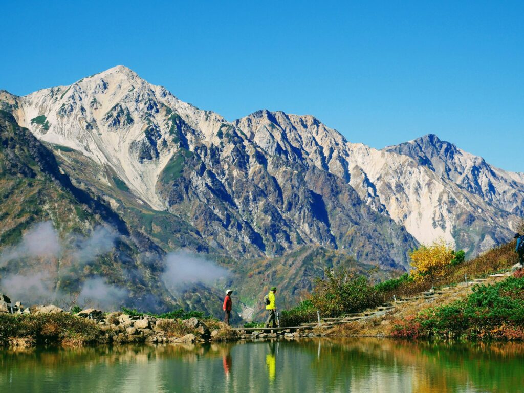 Hikers at Happo Pond above Hakuba with the Northern Alps behind