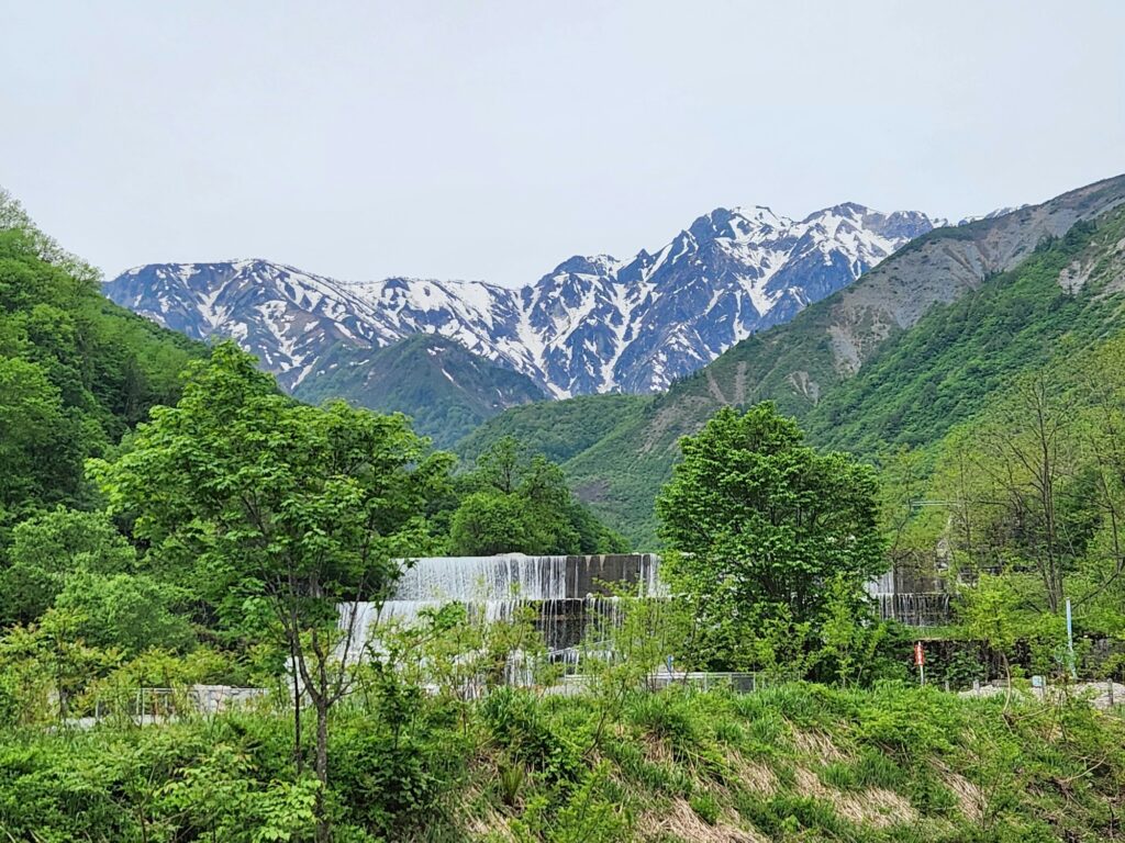 Green fields of Hakuba Village below the snowy Northern Alps