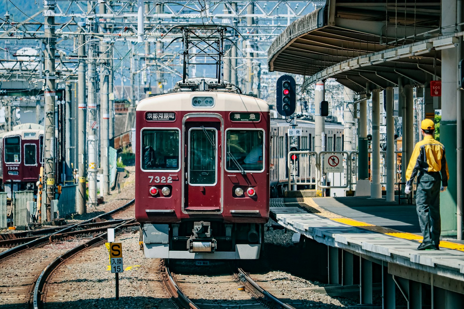 Maroon Hankyu Railway train arriving at a station platform