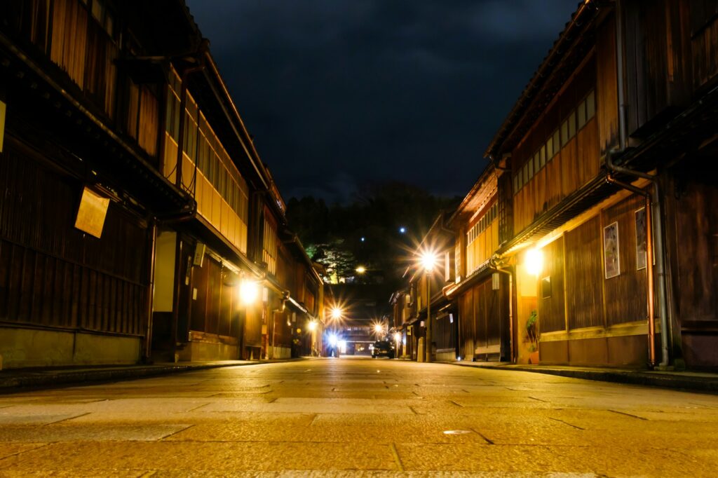 Wooden teahouses lining a lamp-lit street in the Higashi Chaya District at night