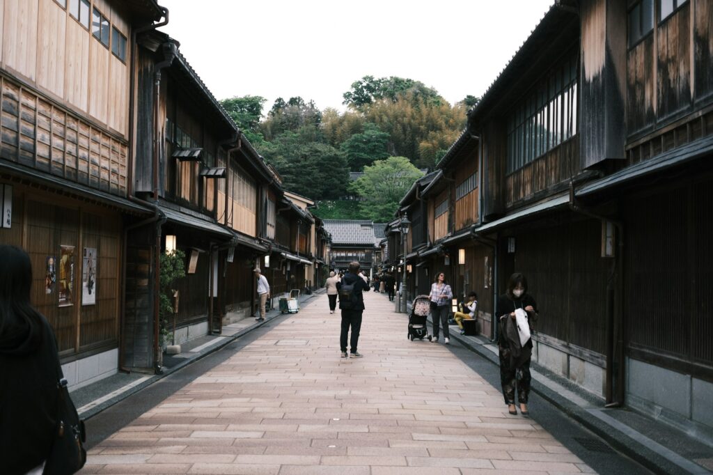 Visitors walking along a wooden teahouse street in Kanazawa