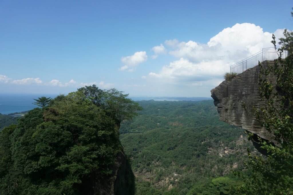 The Jigoku Nozoki rock ledge jutting out from a cliff on Mount Nokogiri with forest below