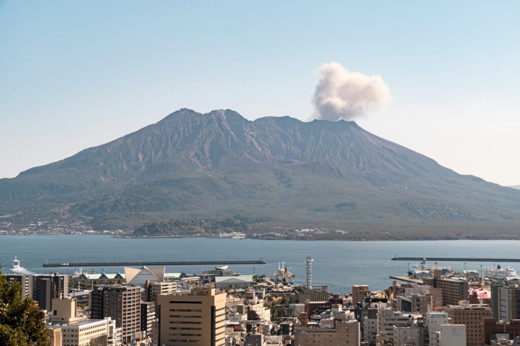 Sakurajima volcano releasing a plume of smoke above downtown Kagoshima