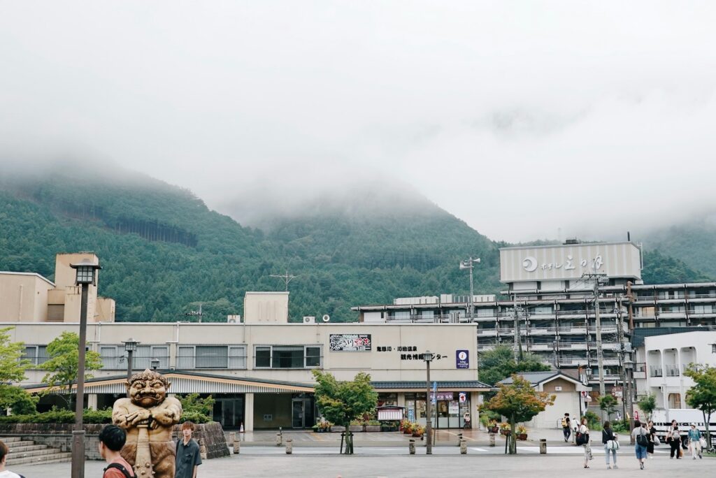 The plaza outside Kinugawa-Onsen Station with clouds over the mountains