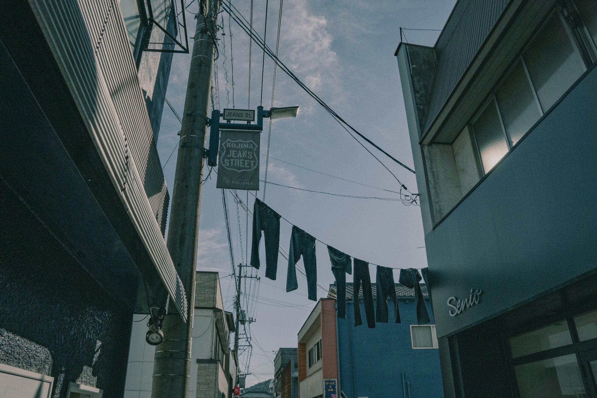 Pairs of jeans hanging on lines above Kojima Jeans Street in Kurashiki