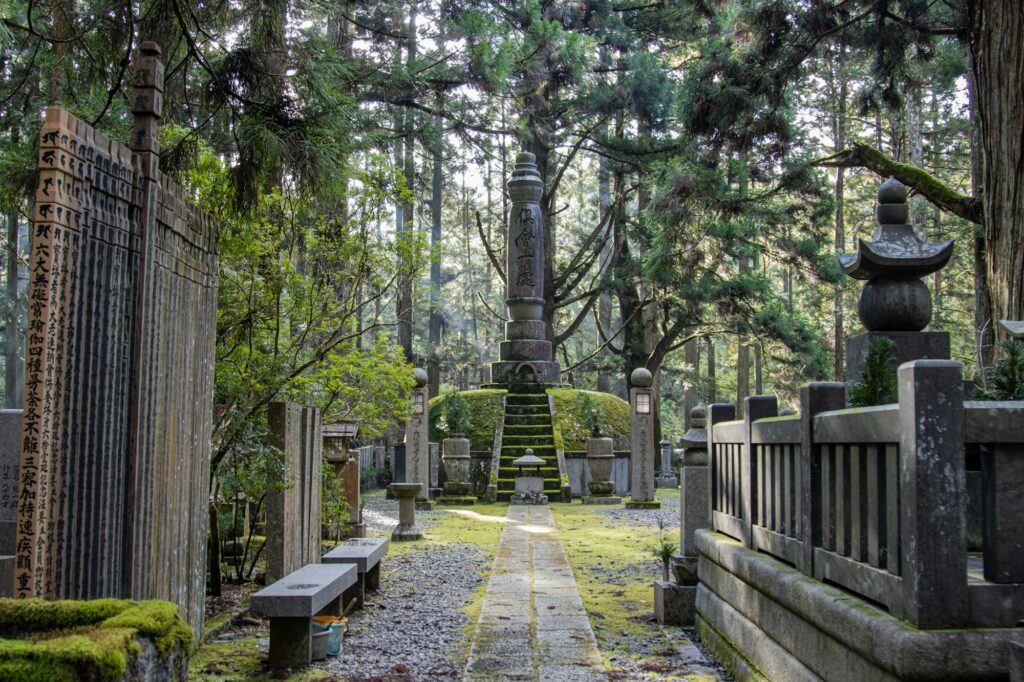 Moss-covered graves and memorial towers in the cedar forest of Okunoin Cemetery on Koyasan