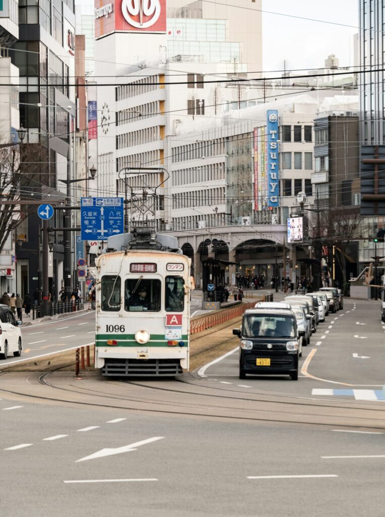 A Kumamoto City tram running along a downtown street