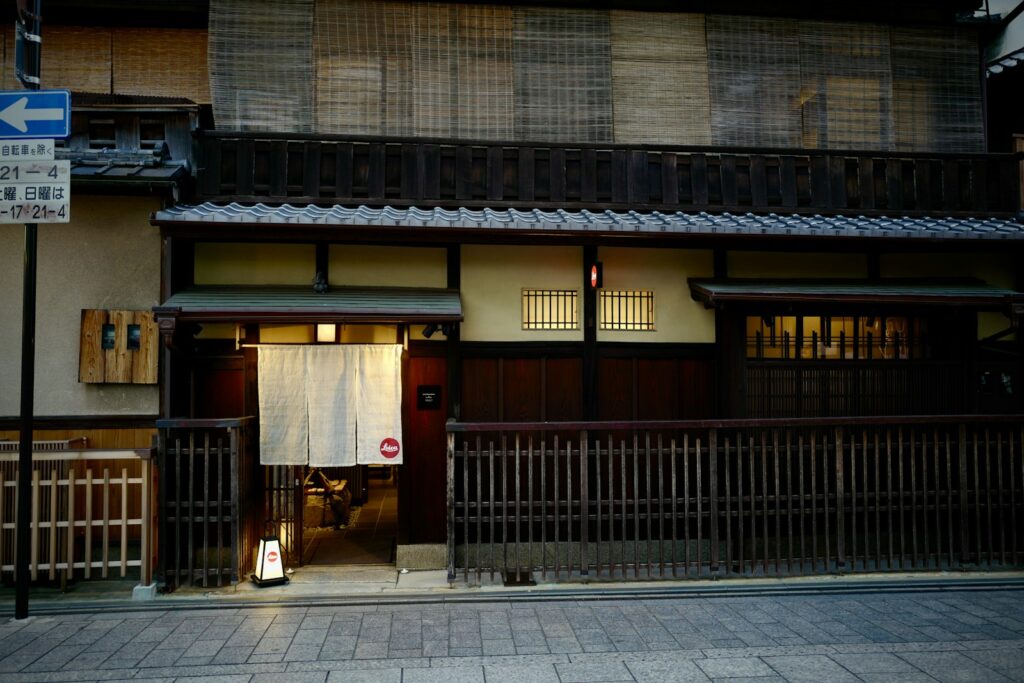 Traditional wooden machiya townhouse with a white noren curtain in Kyoto