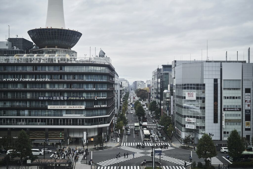 Kyoto Tower above the busy streets in front of Kyoto Station