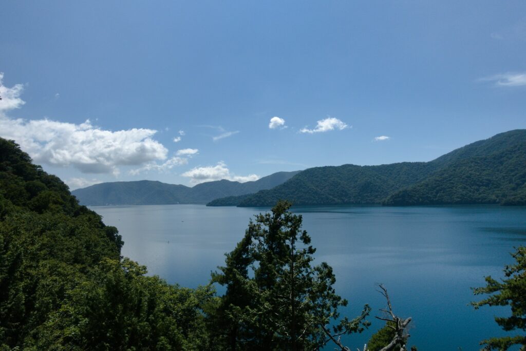 Blue water of Lake Chuzenji with forested mountains