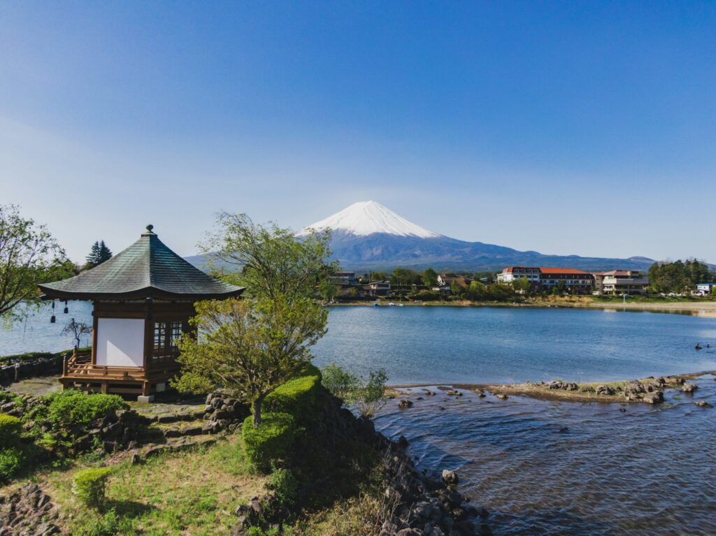 Mount Fuji seen across Lake Kawaguchiko with a small pavilion on the shore