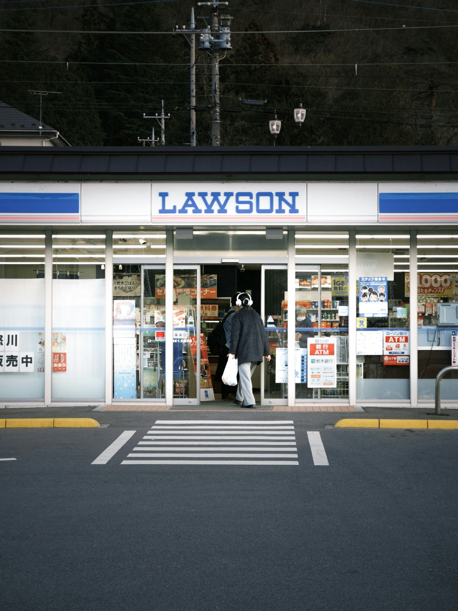 Shopper walking into a Lawson convenience store in Japan