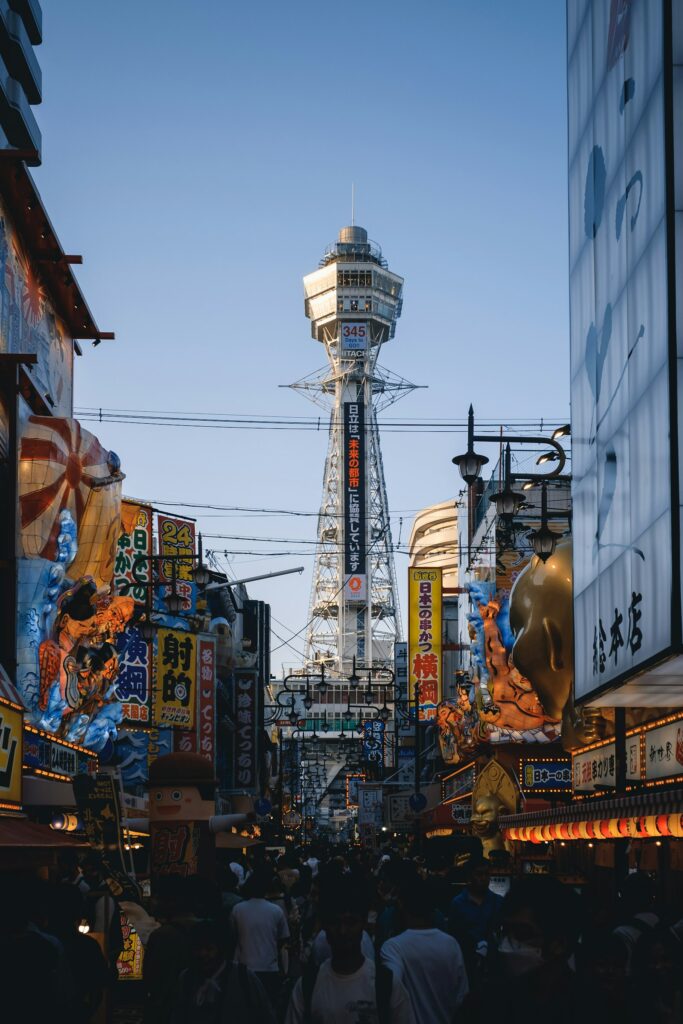 Busy Shinsekai shopping street with Tsutenkaku Tower in Osaka