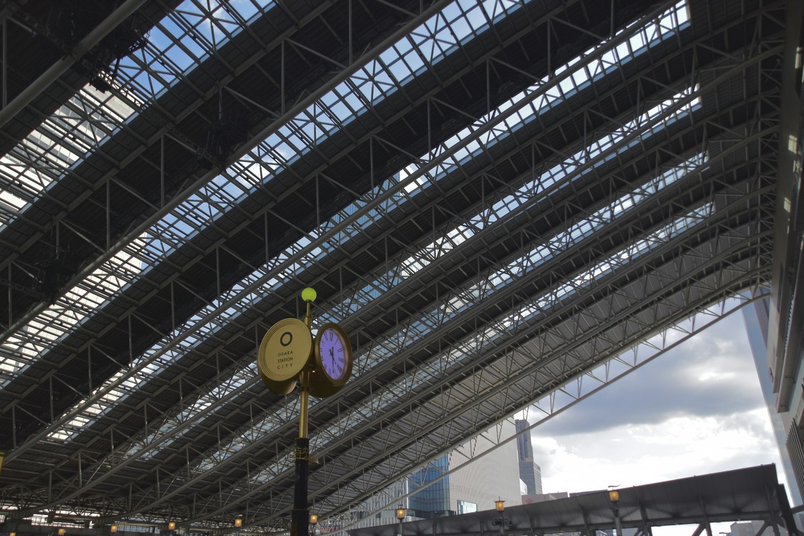 Clock under the glass and steel roof above the platforms at Osaka Station