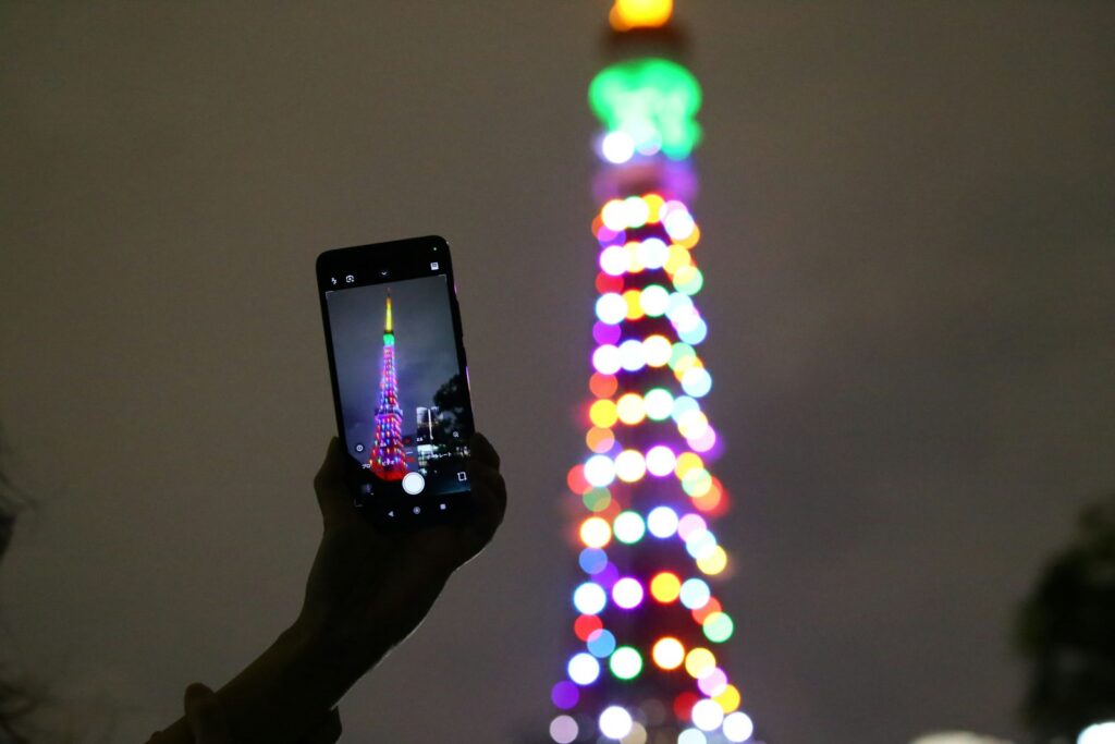 A traveler photographs Tokyo Tower at night. Maps, translation and photo backups all lean on mobile data in Japan.