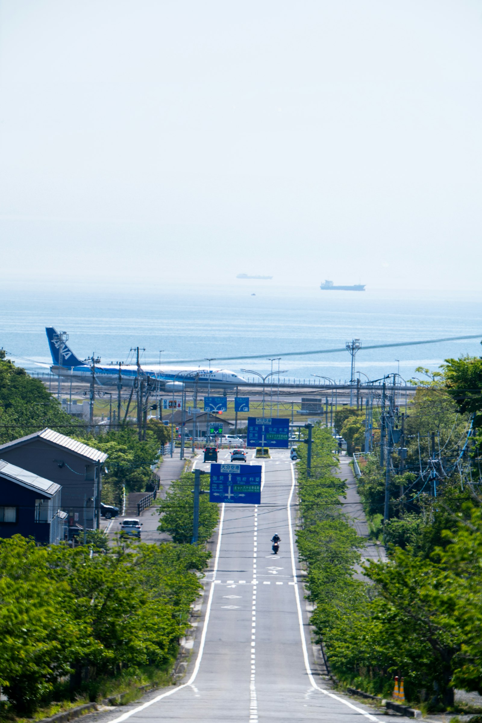 Road leading down toward an airport beside the sea