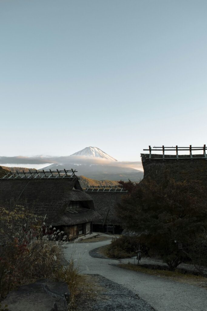 Thatched-roof houses of Saiko Iyashi no Sato Nenba village with Mount Fuji in the background