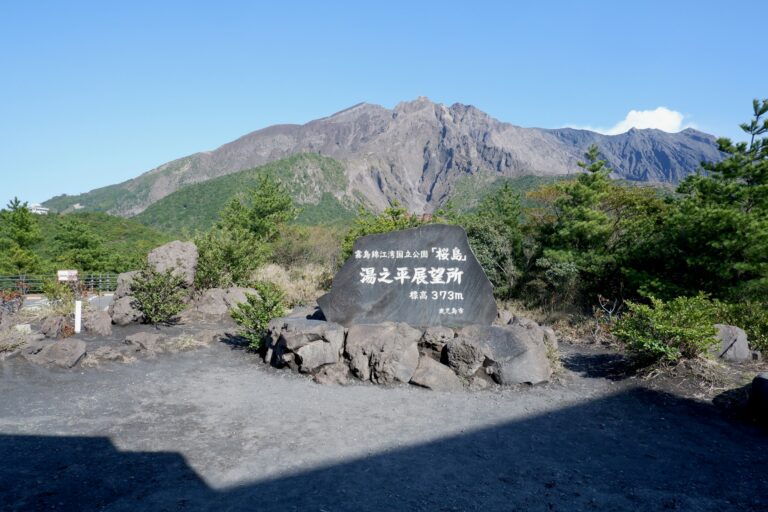 Sakurajima volcano rising behind the stone marker at Yunohira Observatory