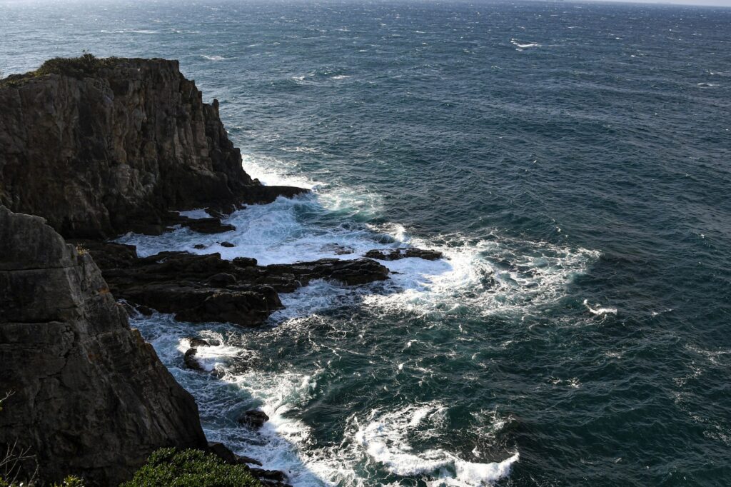 Waves crashing below the sheer Sandanbeki cliffs in Shirahama