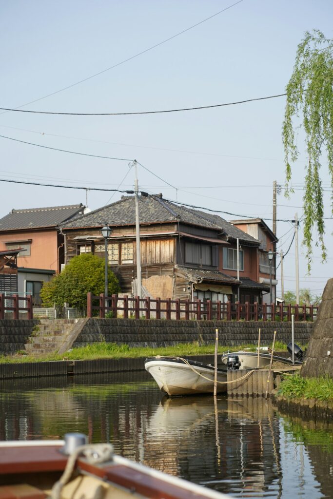 Old wooden merchant houses and moored boats along the Ono River canal in Sawara, Chiba