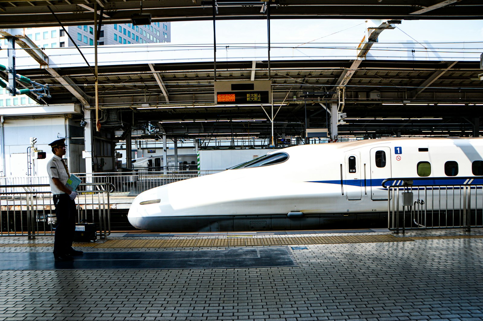 Station staff standing beside a Shinkansen train