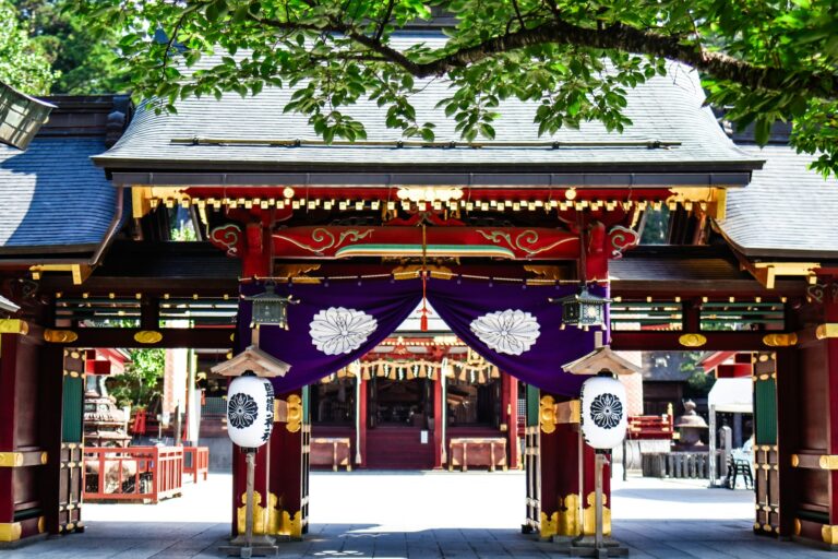The vermilion gate of Shiogama Shrine hung with purple curtains and lanterns